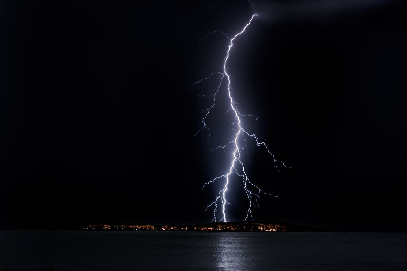 A lightning bolt striking down over a dark horizon