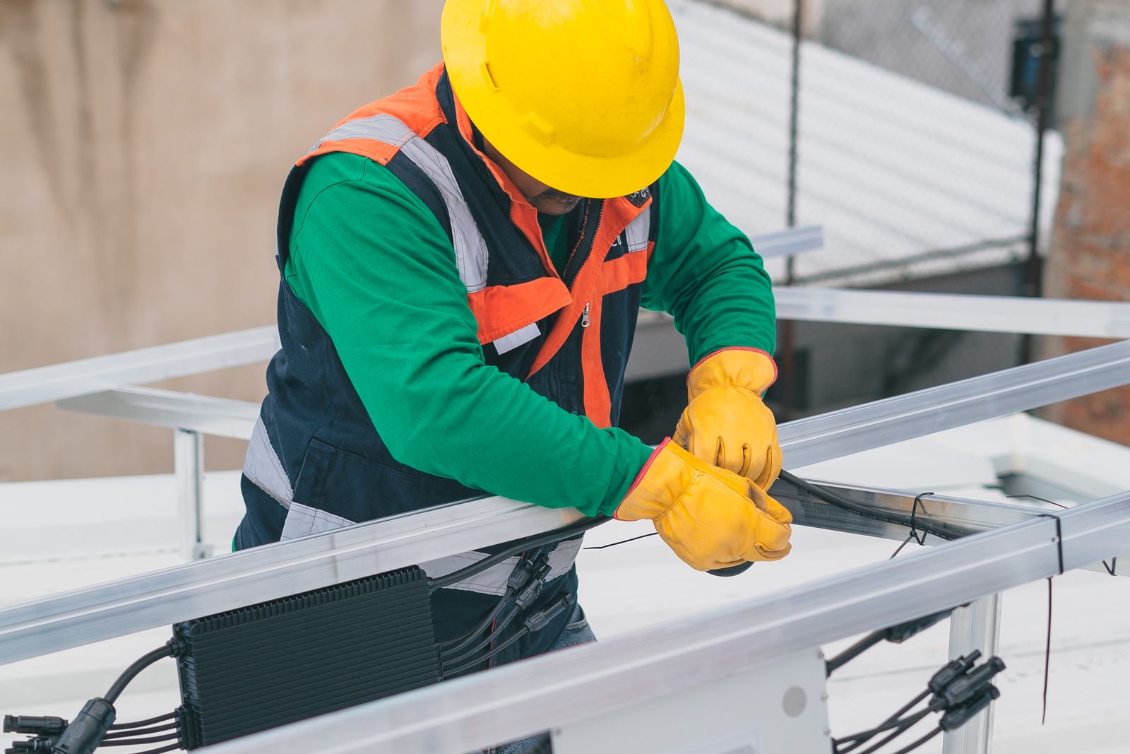 A technician installing conductor rail on a commercial rooftop